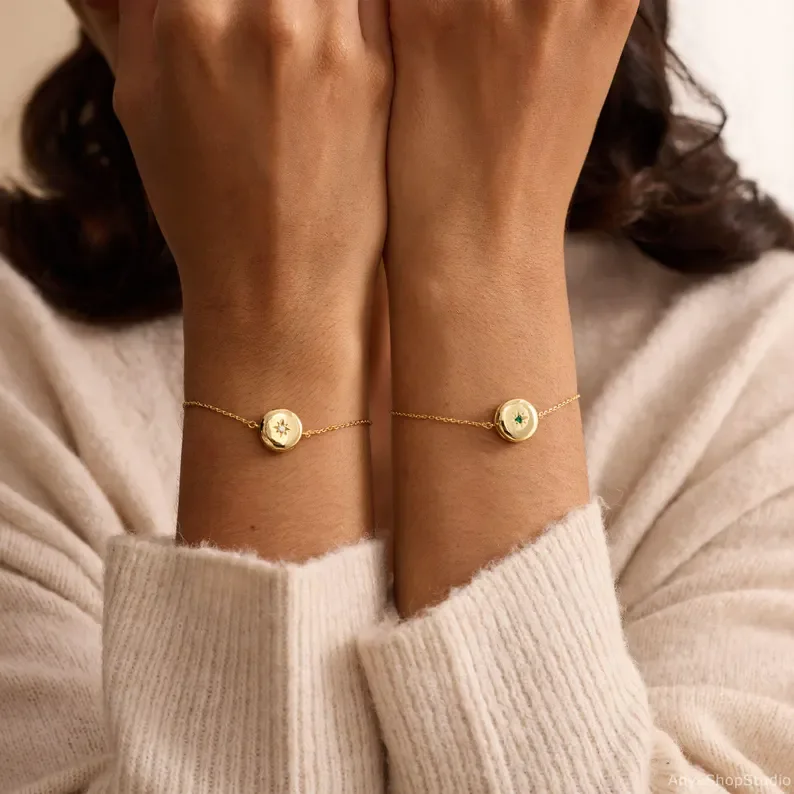 Two locket bracelets with different birthstones, worn on both wrists