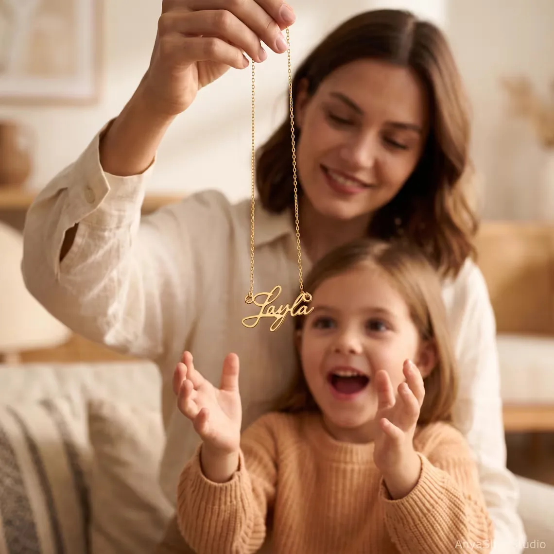 Mother showing her daughter a gold name necklace